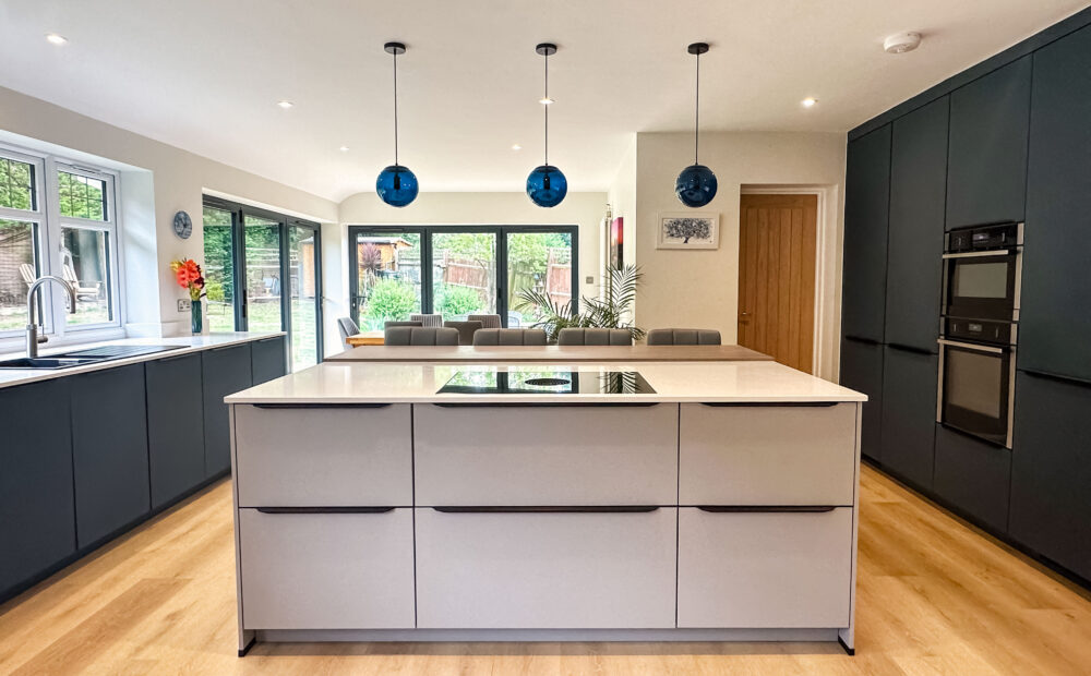 Contemporary grey kitchen with a central island, pendant lights, and sleek appliances