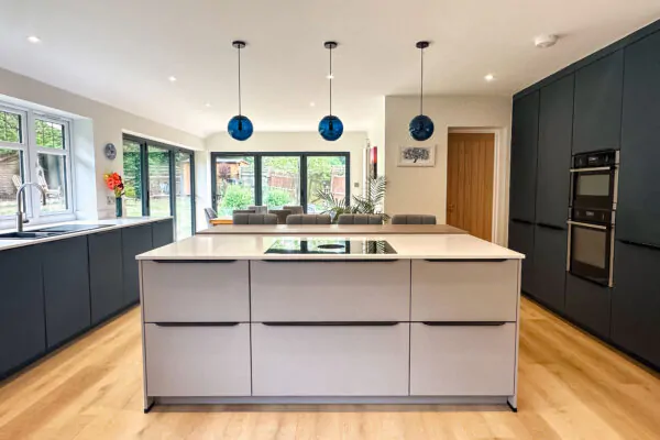 Contemporary grey kitchen with a central island, pendant lights, and sleek appliances