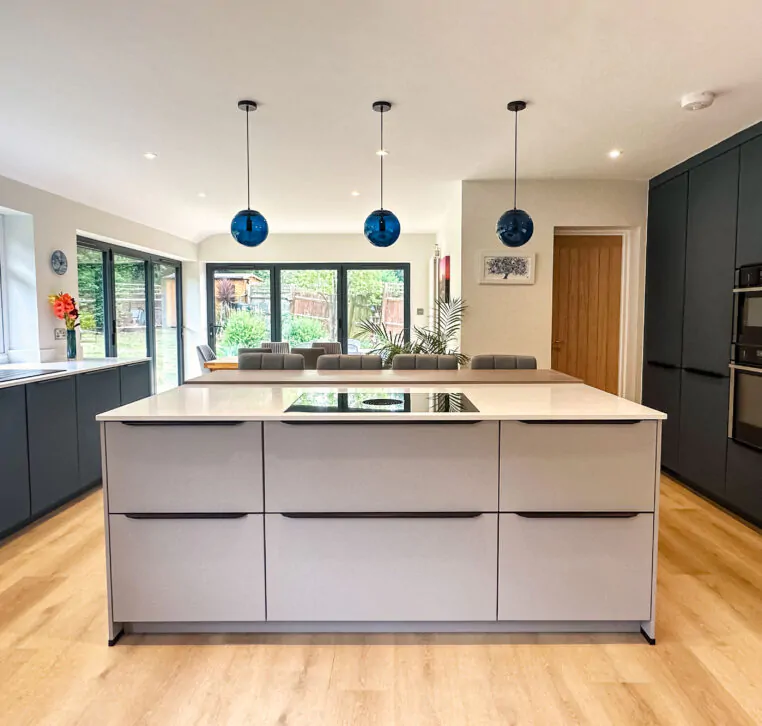 Contemporary grey kitchen with a central island, pendant lights, and sleek appliances