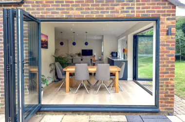 Bifold doors opening to the garden from a modern shaker kitchen with an island