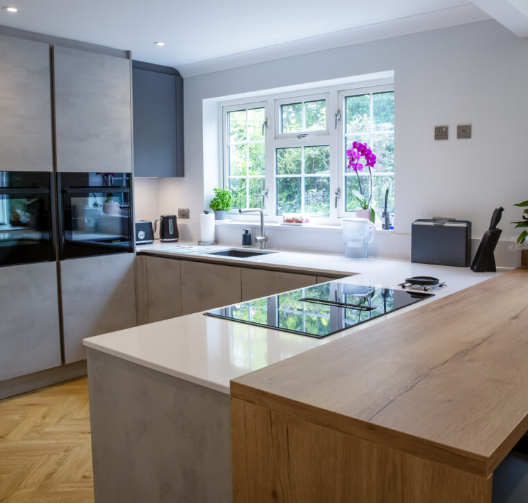 Bright kitchen with large windows, grey cabinets, and a seamless design