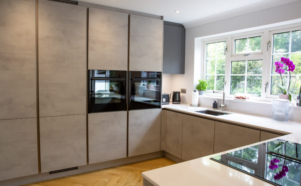 U-shaped kitchen with integrated appliances, white countertops, and a breakfast bar