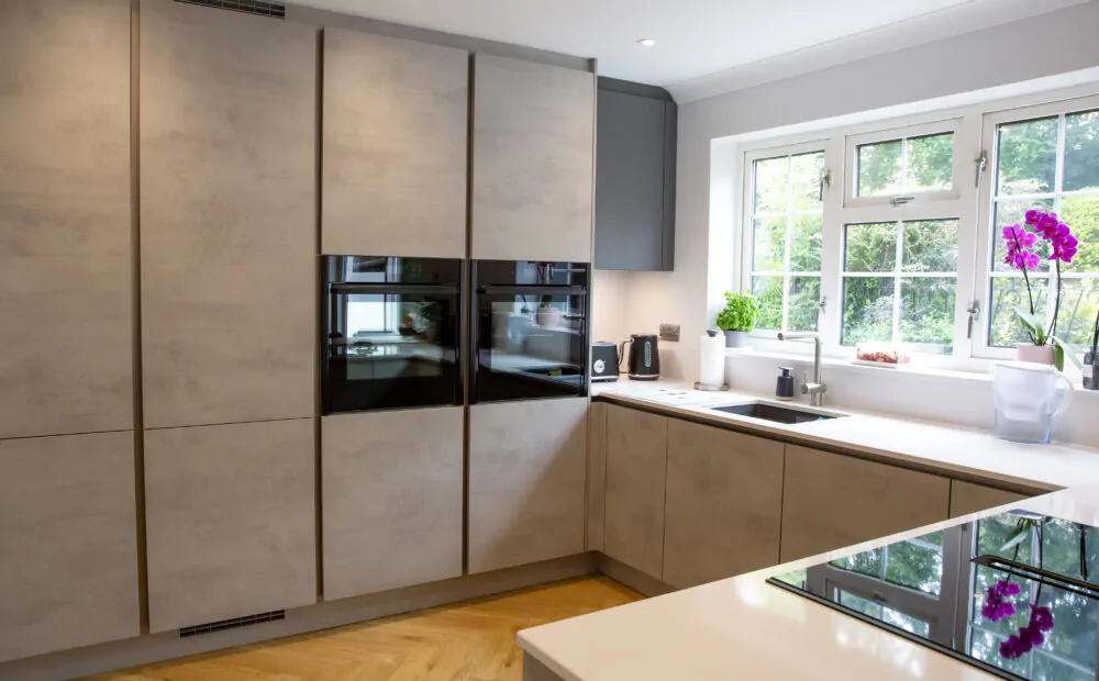 U-shaped kitchen with integrated appliances, white countertops, and a breakfast bar