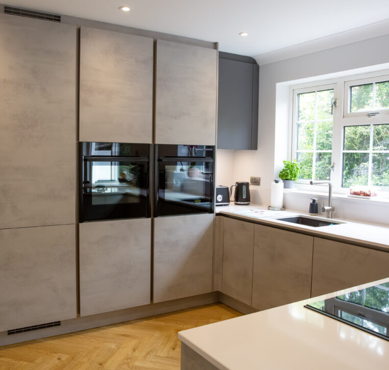 U-shaped kitchen with integrated appliances, white countertops, and a breakfast bar