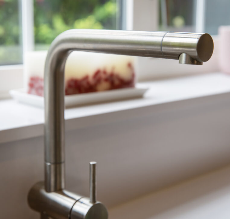Close-up of modern stainless steel kitchen tap with a minimalist design