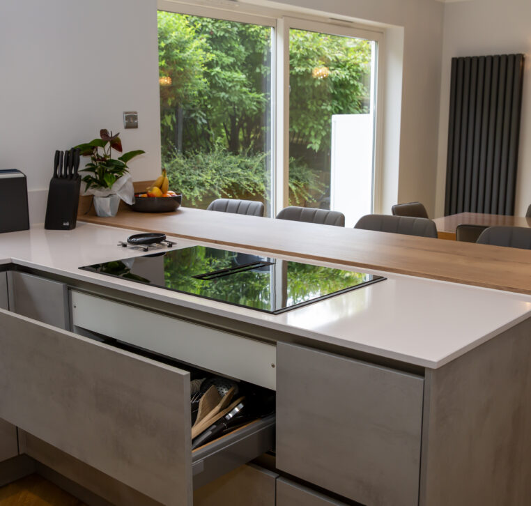 Integrated cooktop and countertop space in a contemporary kitchen with stone-effect cabinets