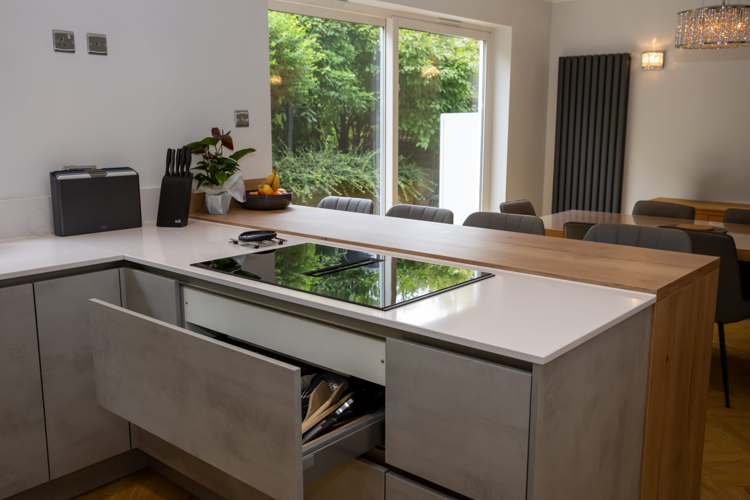Integrated cooktop and countertop space in a contemporary kitchen with stone-effect cabinets
