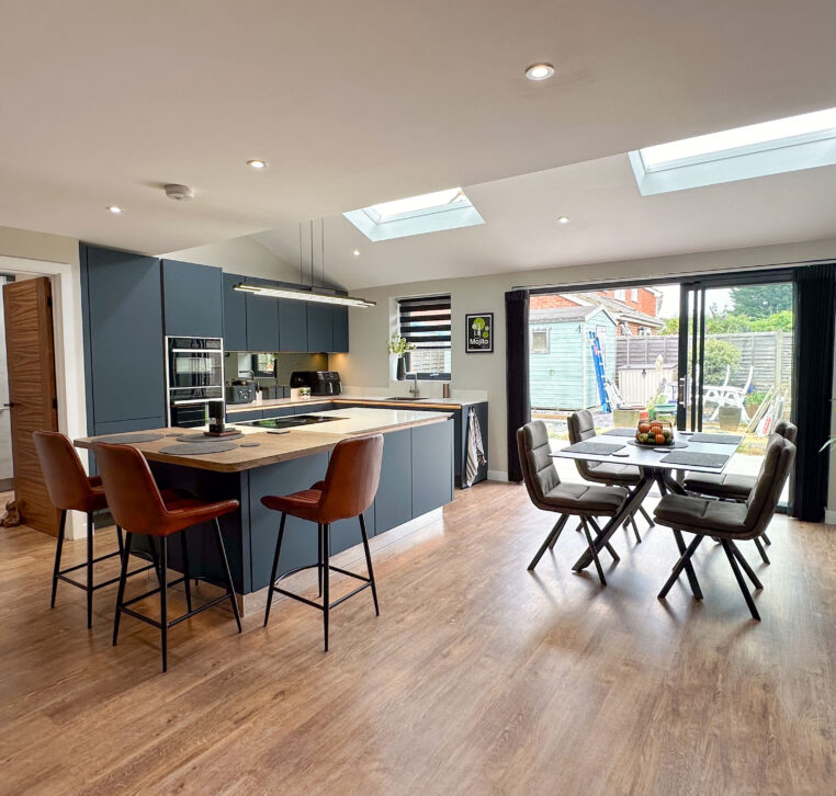 Full view of the open-plan kitchen with large island, skylights, and integrated dining area.
