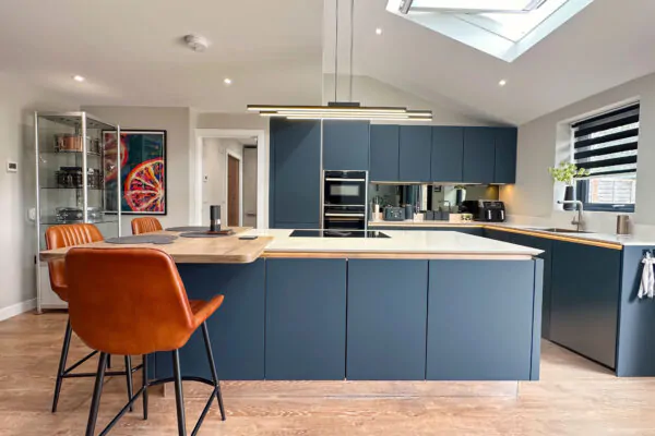 Modern kitchen showcasing a sleek design with dark cabinetry, white countertops, and oak breakfast bar.