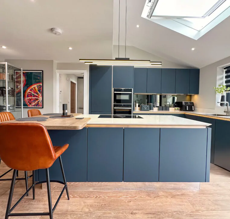 Modern kitchen showcasing a sleek design with dark cabinetry, white countertops, and oak breakfast bar.