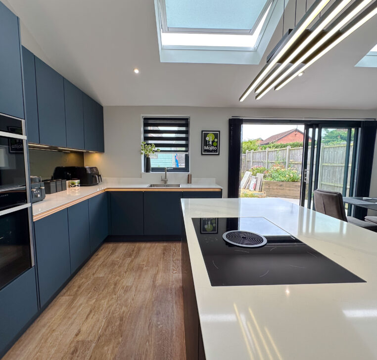 Modern kitchen showcasing a sleek design with dark cabinetry, white countertops, and oak breakfast bar.