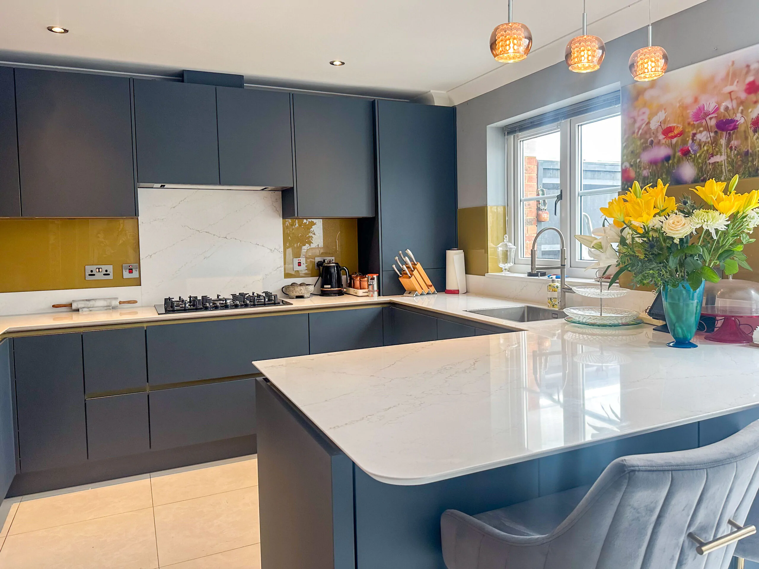 U-shaped kitchen with a peninsula, gold Line N cabinets, and quartz worktop.