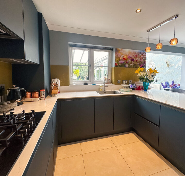 Spacious modern kitchen with integrated lighting, gold cabinets, and a 5-ring gas hob.