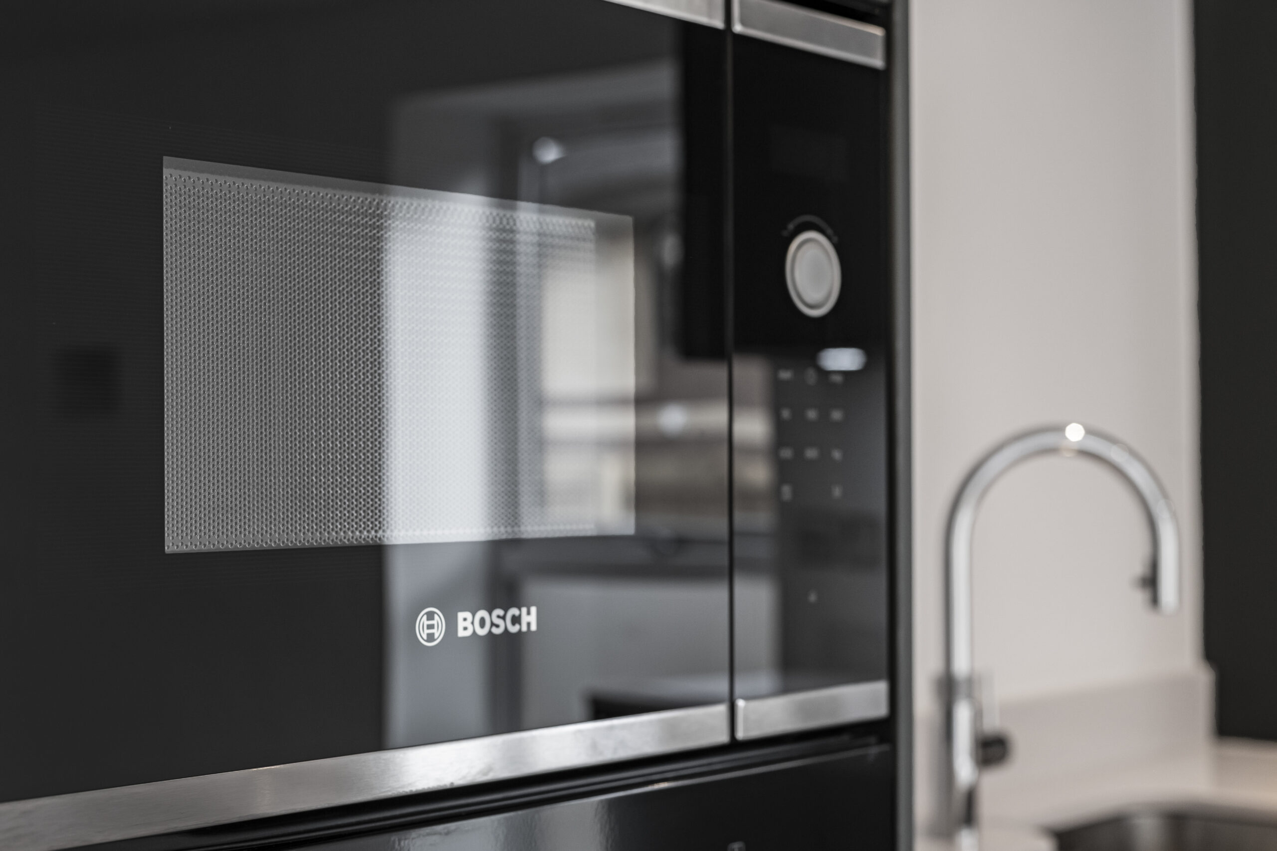 Close-up of Bosch integrated microwave in a modern contract kitchen