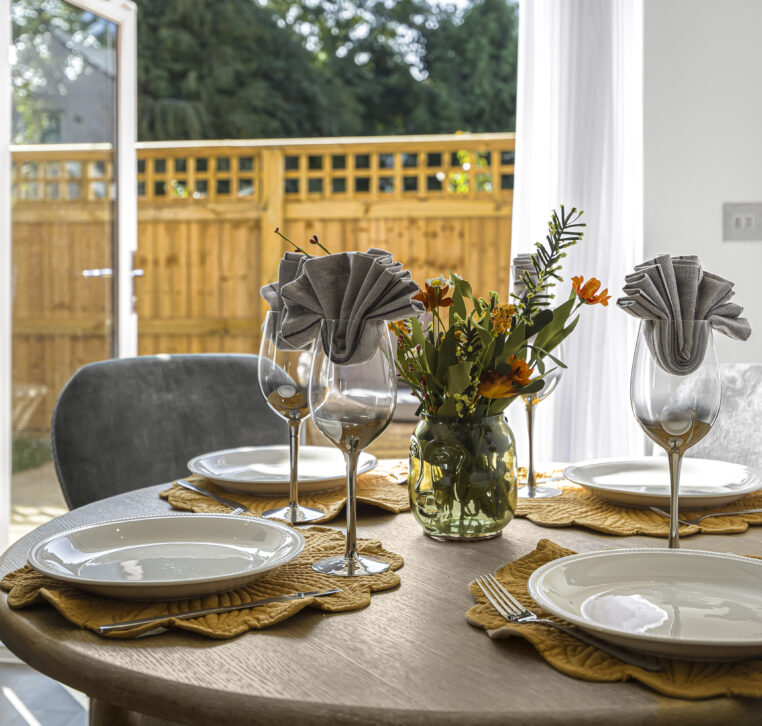 Detailed view of dining setup with flowers on a wooden round table in a modern contract kitchen