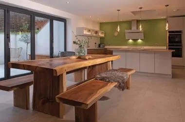open plan kitchen with wooden table and benches.