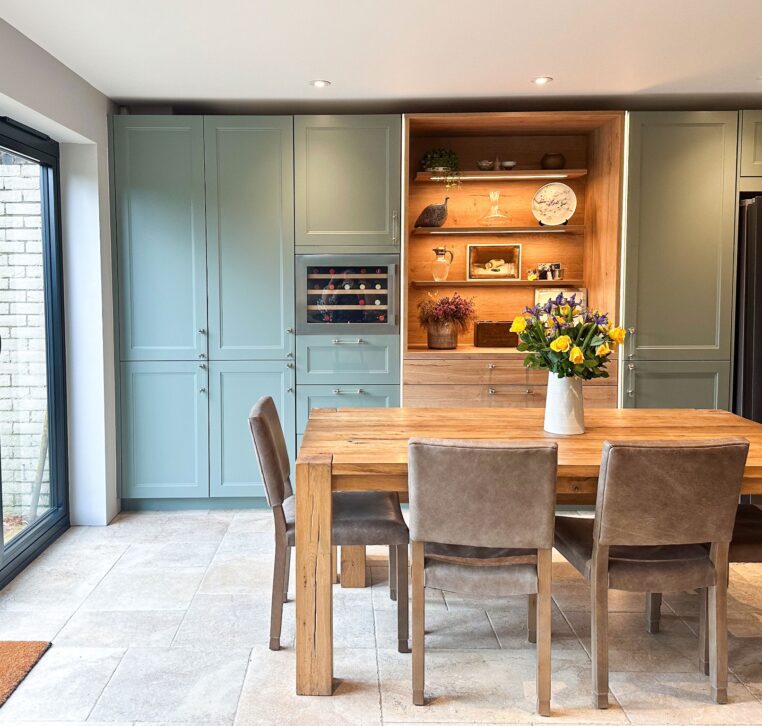 Spacious light U-shaped wood shaker kitchen featuring a built-in wine cooler and display shelves