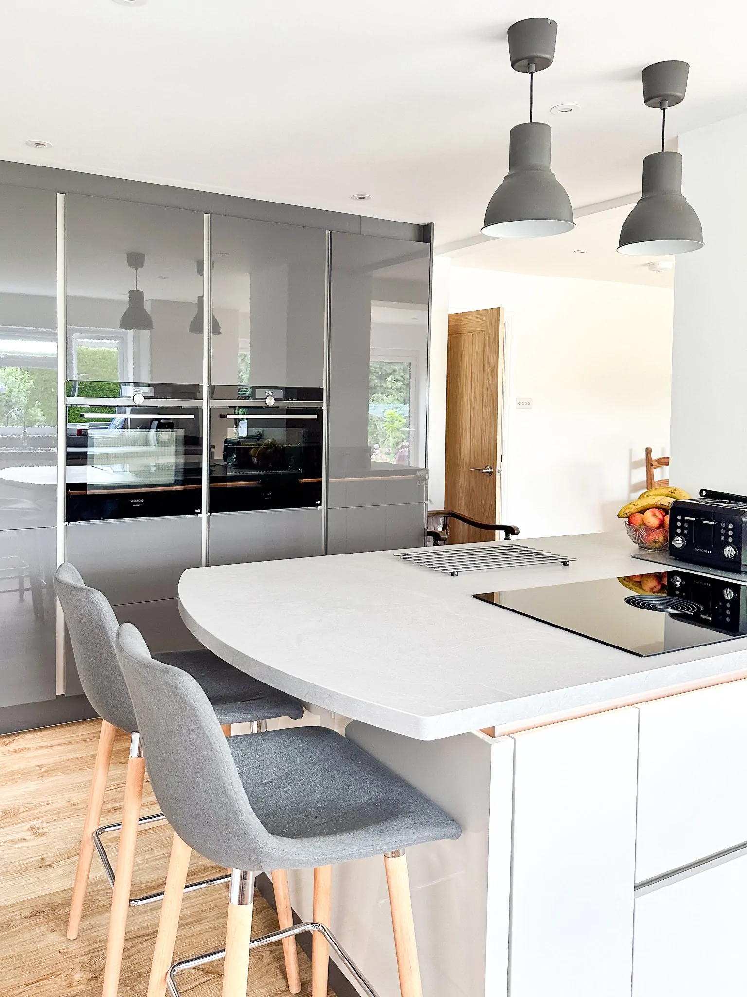 Open-plan kitchen featuring a modern island, wine rack, and high stools