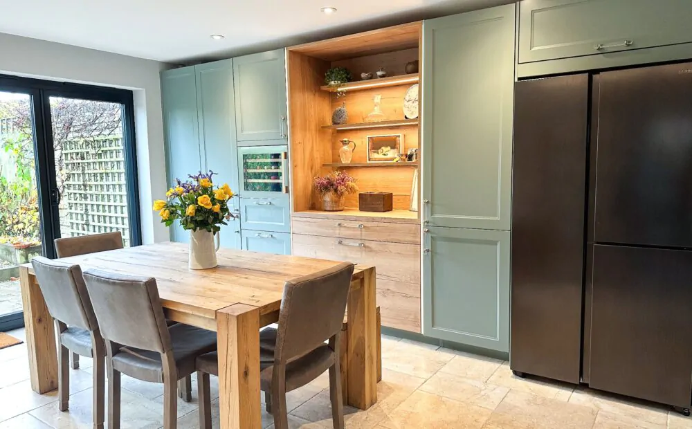 Modern wood shaker kitchen with a rustic wooden dining table and garden view
