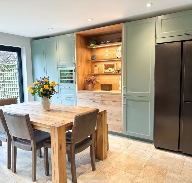 Modern wood shaker kitchen with a rustic wooden dining table and garden view