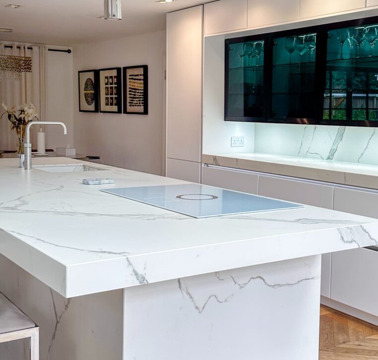 A modern kitchen with built-in high-end appliances, marble surfaces, and a sophisticated neutral color palette.