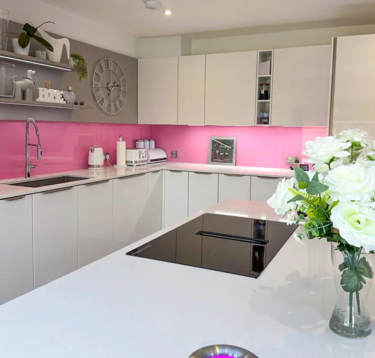 Modern kitchen white island with pop-up waste bin illuminated by purple LED light.