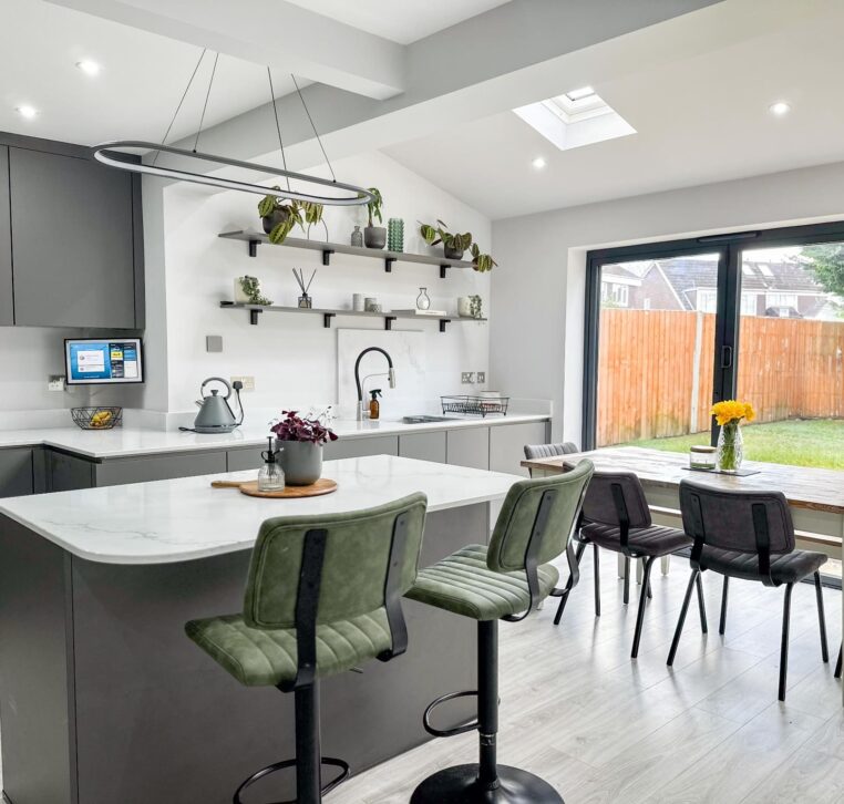 Close-up of grey kitchen island with white quartz worktop and built-in wine fridge.