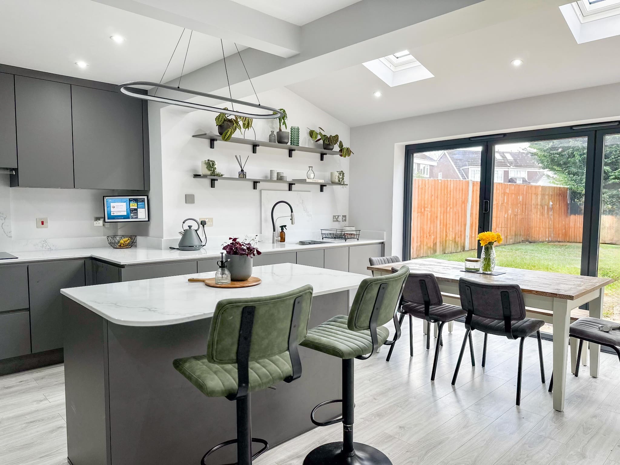 Close-up of grey kitchen island with white quartz worktop and built-in wine fridge.