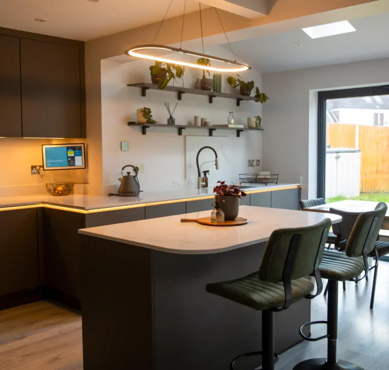 Stylish grey kitchen diner with skylights, pendant lighting, and sliding doors to the garden.