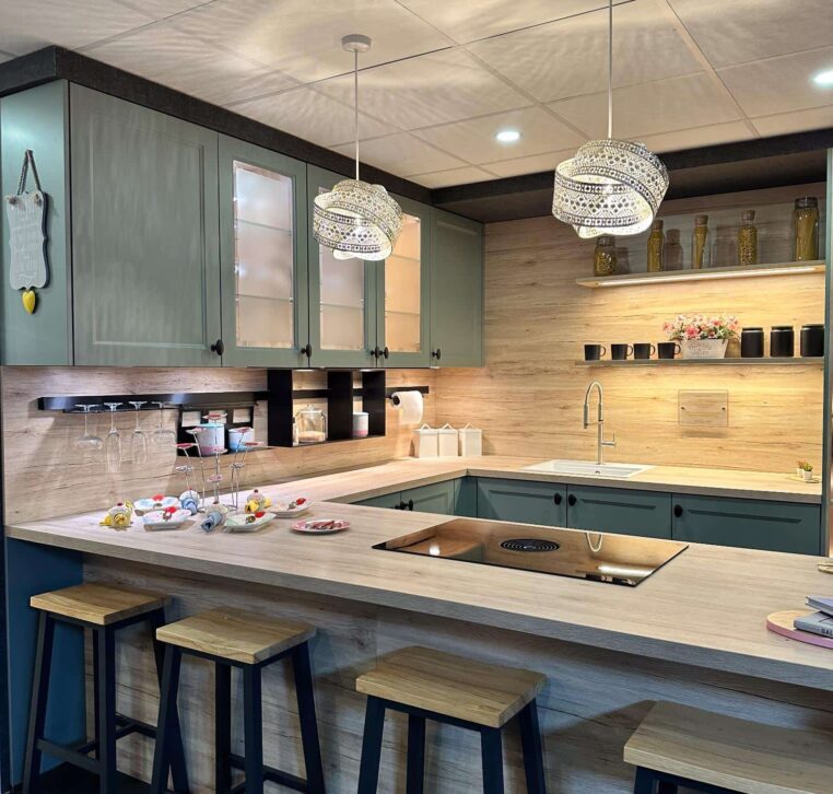 Contemporary green kitchen with open shelving, light wood countertop, and modern appliances.