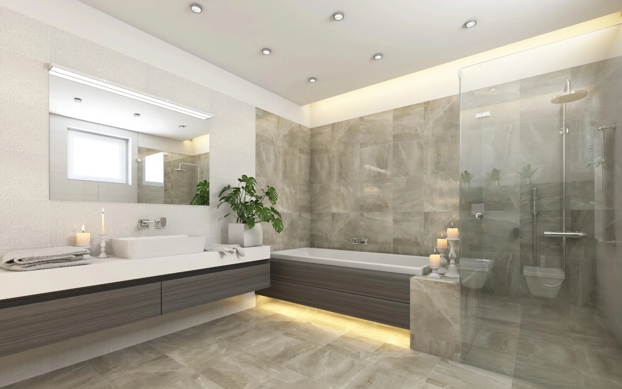 A stylish bathroom with light grey tiles, a freestanding bath, and a large mirror. The space is illuminated by recessed ceiling lights, and plants are placed for added warmth.