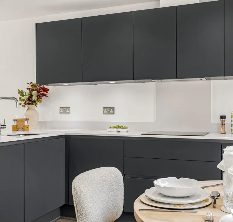 Modern kitchen with dark grey cabinets and white countertops