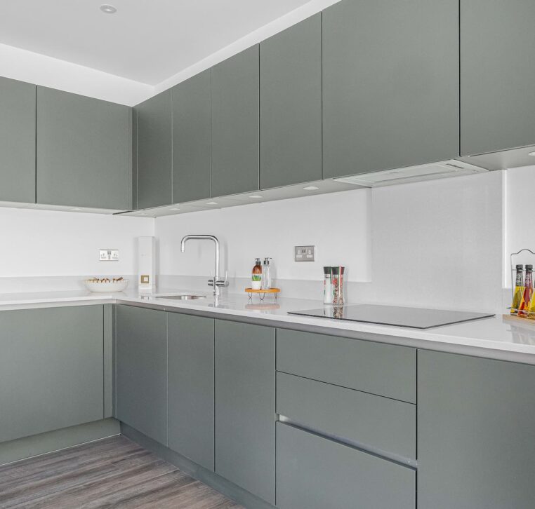 Sleek grey kitchen with minimalist design and white backsplash