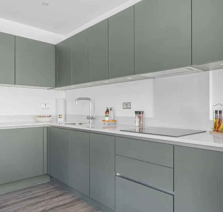 Sleek grey kitchen with minimalist design and white backsplash