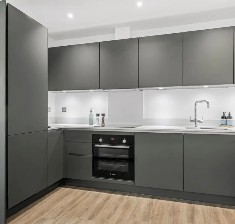 Modern grey kitchen with built-in oven and wood flooring