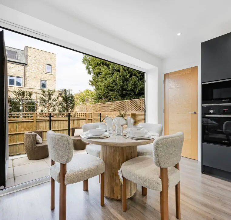 Open-plan kitchen with folding doors and round dining table
