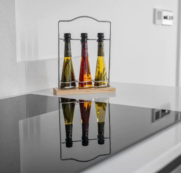 Sleek hob with trio of infused oils on reflective surface