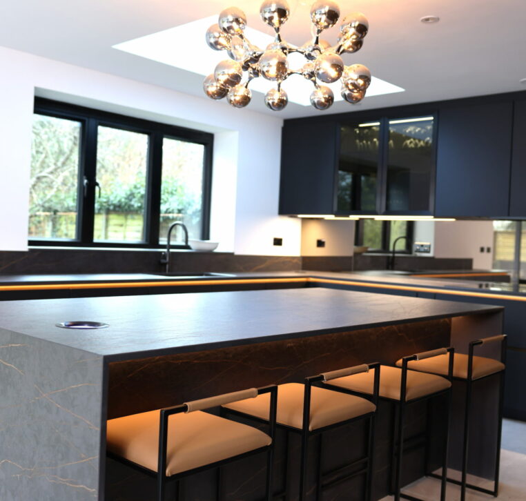 Kitchen island with bar seating, modern lighting and dark cabinetry detail