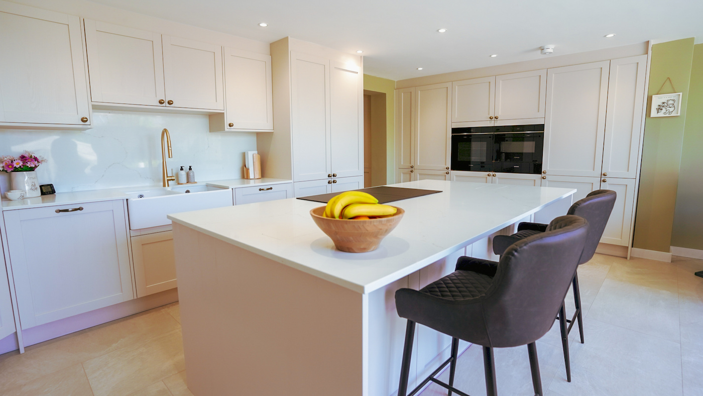 Luxury shaker kitchen with large island, integrated appliances and elegant neutral finishes by MAS Kuchen.
