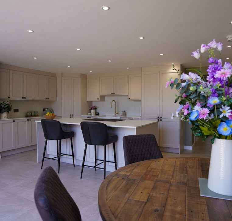 Open-plan family kitchen with shaker cabinetry, central island and dining area designed by MAS Collection.