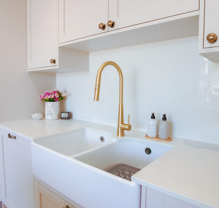 Shaker kitchen featuring a Belfast sink, brass tap and quartz worktops installed by MAS Collection.